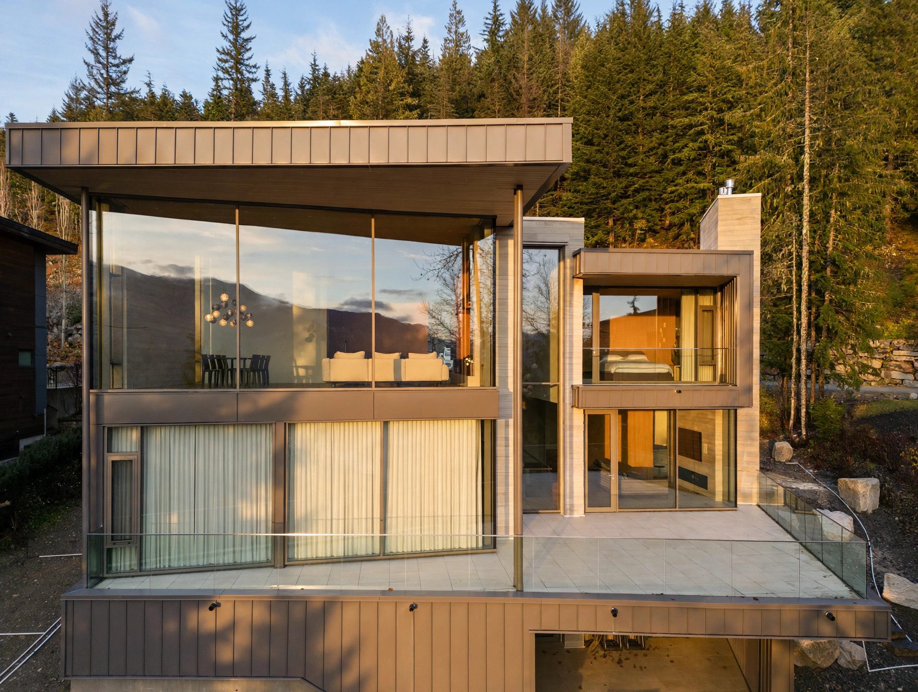 Modern glass mountain residence in golden-hour light