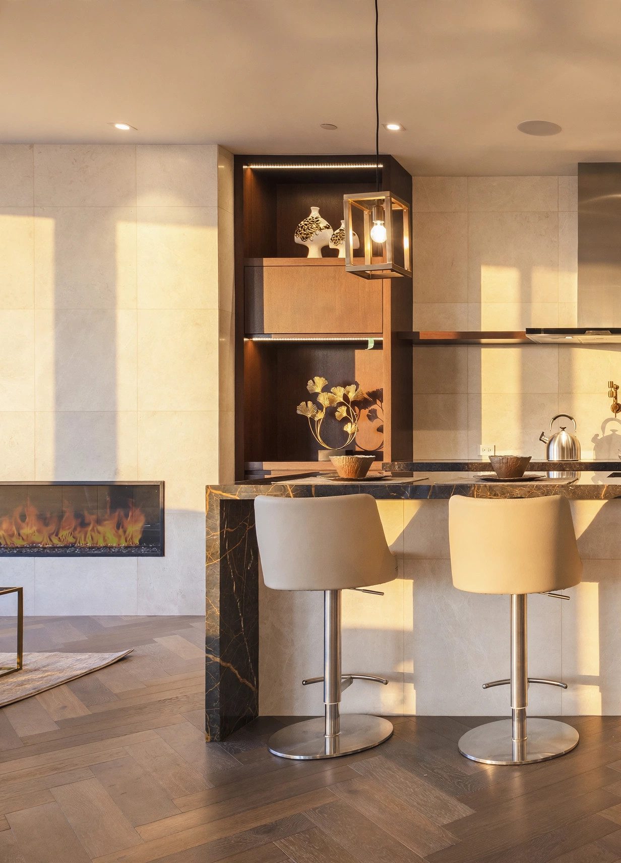 Sunlit marble bar and fireplace with herringbone wood floor